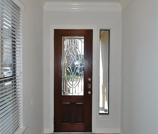 Inviting entry with tile floors, high ceiling and crown molding