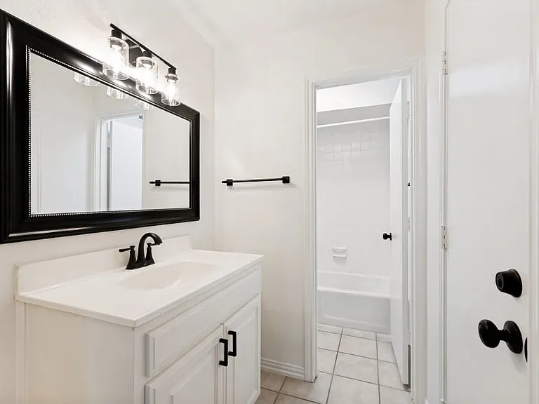 White vanity with integrated sink and matte black hardware