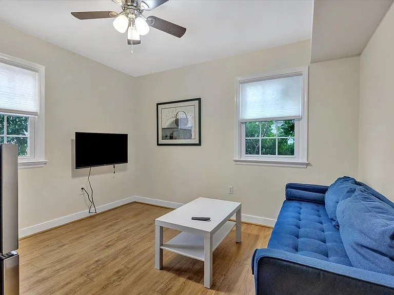 Second living/TV space with dorm-sized refrigerator.