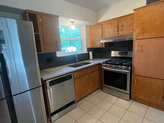 Bright MCM kitchen with new SS appliances, granite counters, and new tile backsplash.