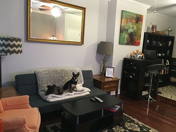 Main living area with large front window, hard wood floors,