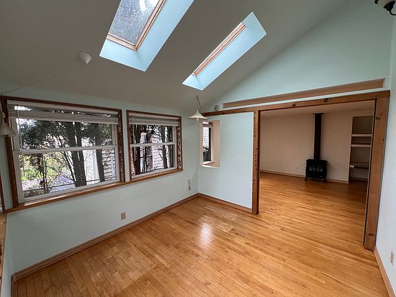 Sunroom inside the front door with skylights, view into living room.