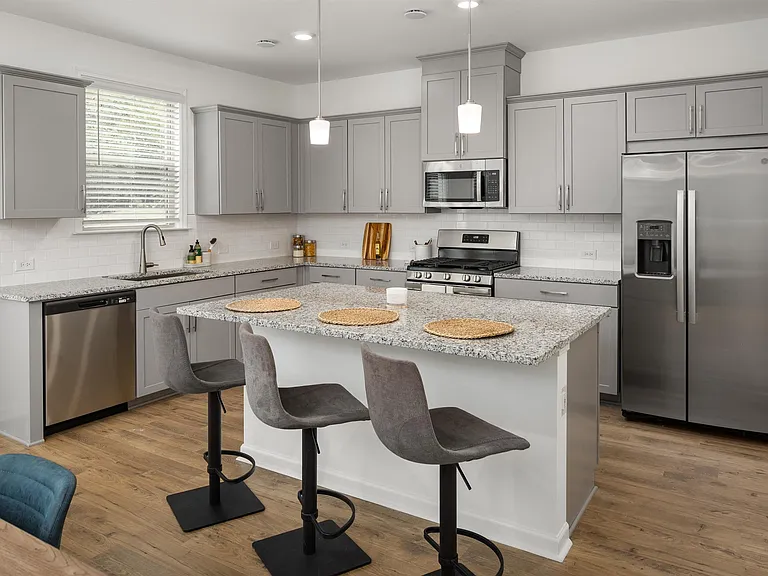 View of the kitchen and entry hallway. Offering bar seating, plenty of cabinet space and granite countertops.