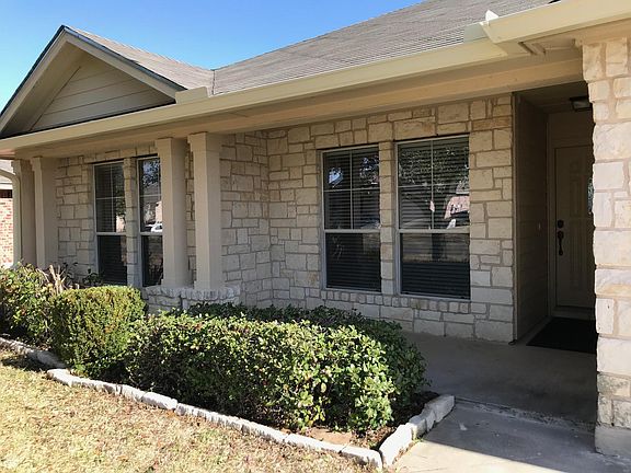 Front view of new guttering, vegetation, entryway, porch, and bedroom windows 1& 2.