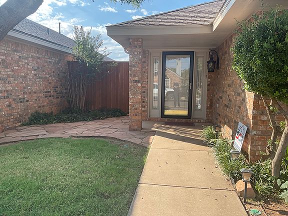 Front door with patio area in front yard
