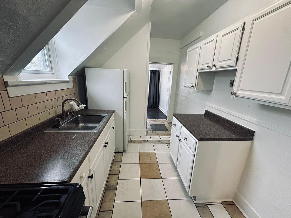 Kitchen, left second back entry staircase to back yard, bedroom in the back.
Fridge, gas stove, sink. North facing window.