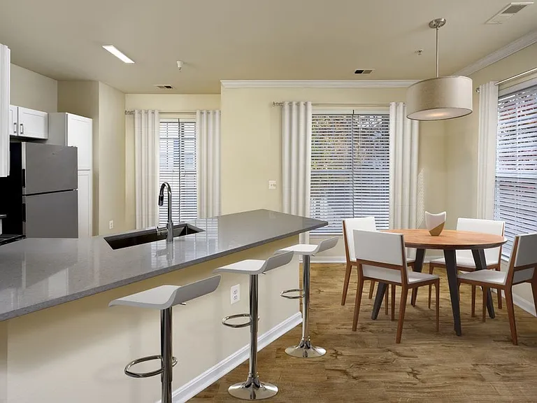 Renovated Package I kitchen with stainless steel appliances, grey quartz countertops, white cabinetry, and hard surface flooring