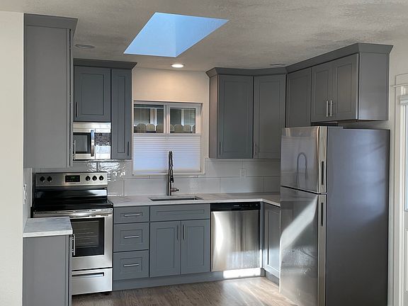 Kitchen with all stainless steel appliances, quartz counter-top, skylight