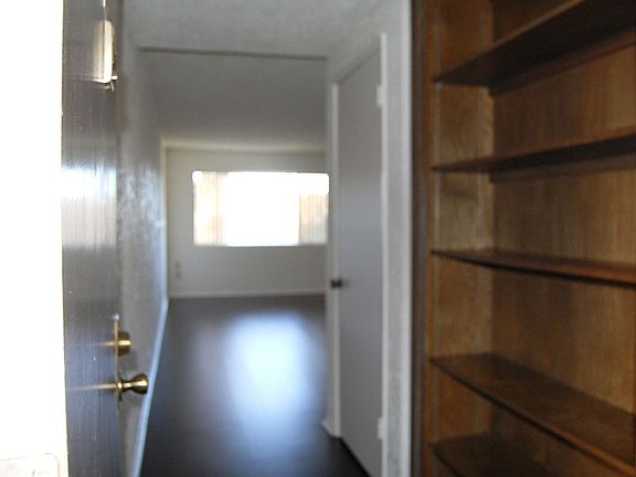 Entry leads past built-in book shelves and coat closet towar