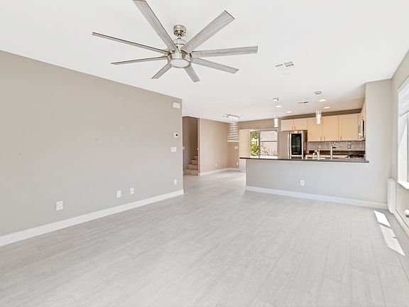 Bright Living Spaces: Natural light floods in through custom window coverings, creating an inviting ambiance in the expansive living and dining areas.