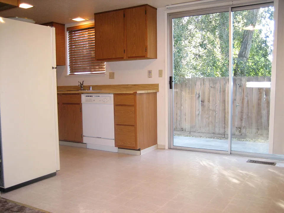 View of kitchen, dining area and private patio, small yard.