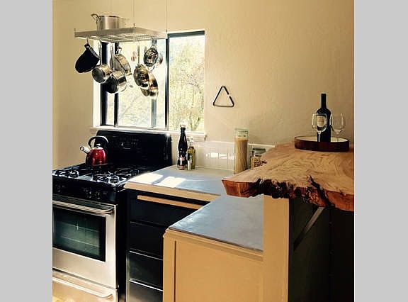 Natural wood counter bar separates kitchen from living area