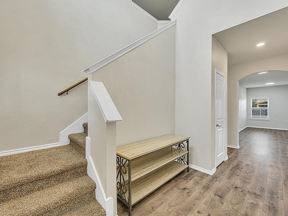 Carpeted staircase with wooden handrail