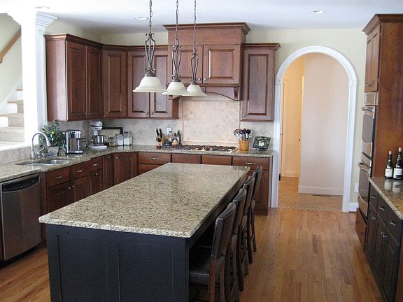 The Kitchen features a long island, double oven, and decorative vented hood.