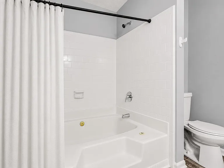 Primary bathroom with tiled tub/shower combo.
