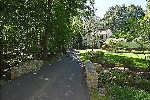 Cross over your own stone bridge to enter this beautifully landscaped property.