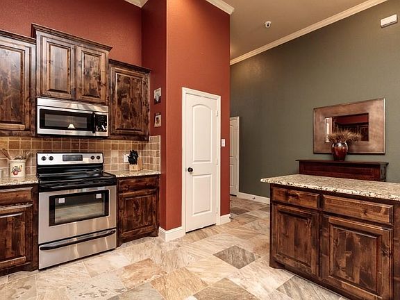 Kitchen features includes custom accented tiled back splash and stainless steel appliances.  Beautiful on-site finished customer knotty alder cabinets.