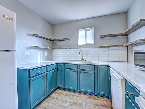 Kitchen - (the following are all new) quartz countertops with large undermount sink, new hood above stove, ceiling lighting, flooring, backsplash, floating shelves, cabinet color with gold/black accents