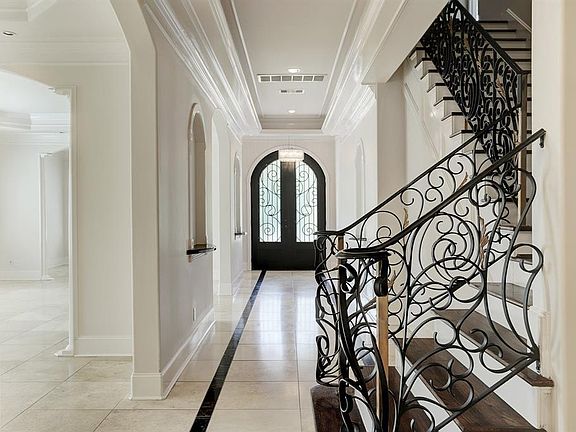 Beautiful entry with Travertine floors throughout; ornate front door and staircase banister.