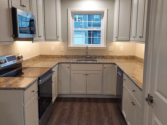 Galley Kitchen with white cabinets and granite countertops