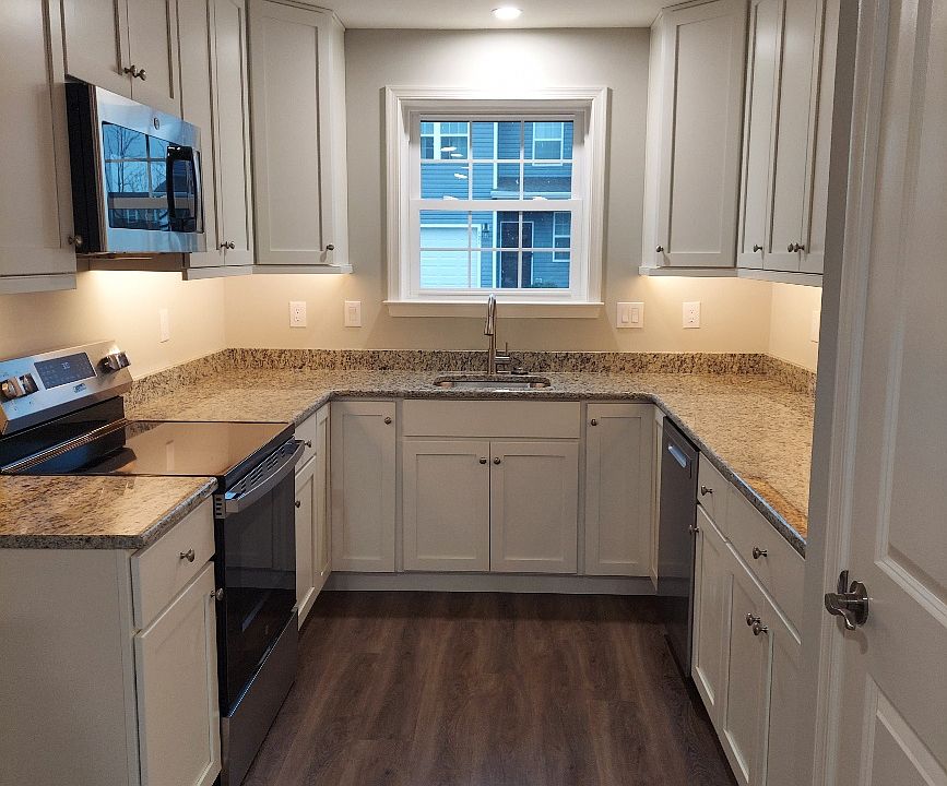 Galley Kitchen with white cabinets and granite countertops