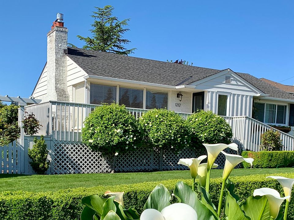 Charming white cape cod style home with manicured yard