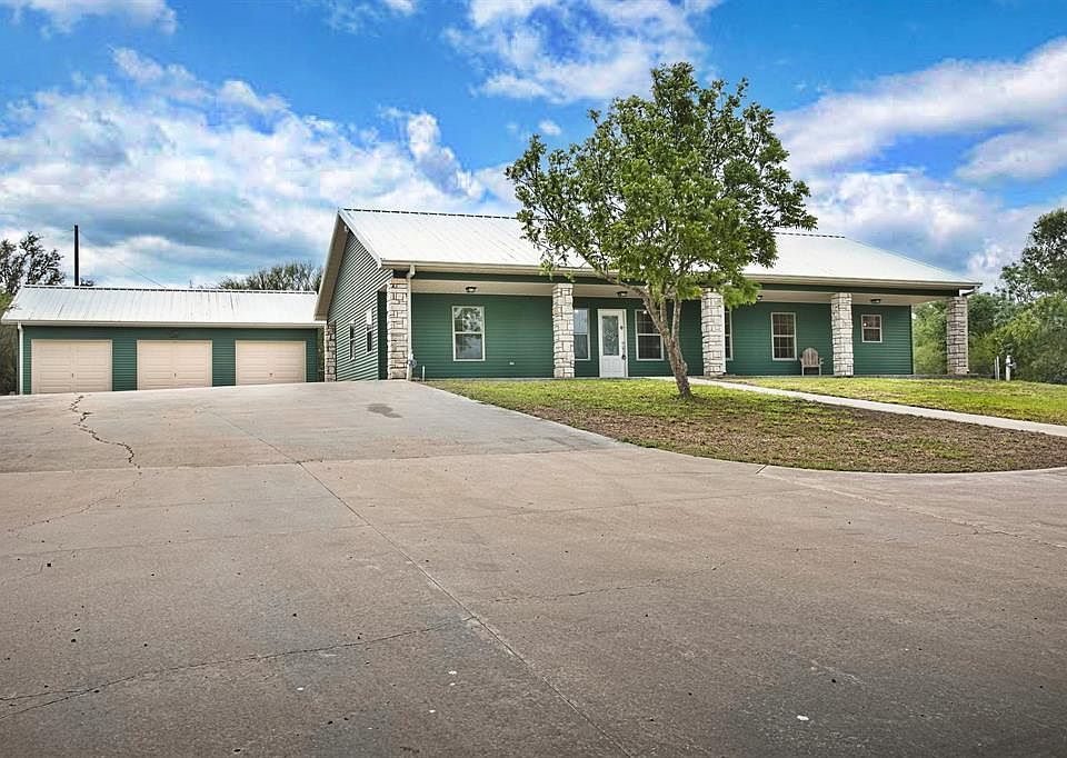 9.65 acres with a 2/2 home with many custom touches with a 3 car garage with a full bathroom.