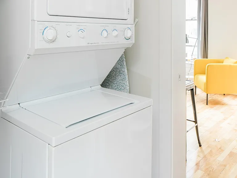 Updated bathroom with pocket door includes stacked washer/dryer and tiled shower