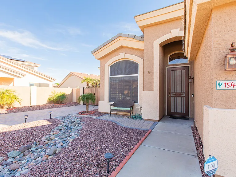 Enjoy a paved front porch w/ loveseat, tropical low maintenance & river rock front landscaping