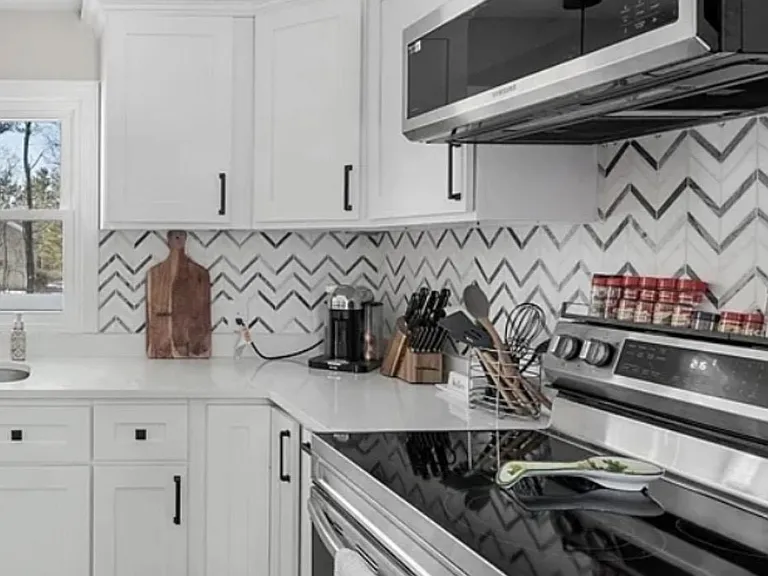 Well-appointed kitchen with ample cabinet storage, generous counter space, and stainless steel range with over-the-range micr