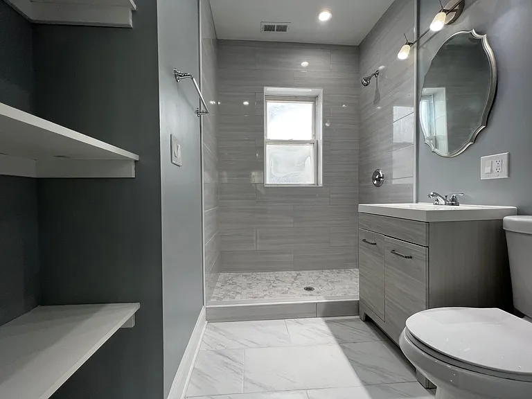 Newly renovated bathroom with linen closet. Note: glass shower door will be installed before tenant moves in.