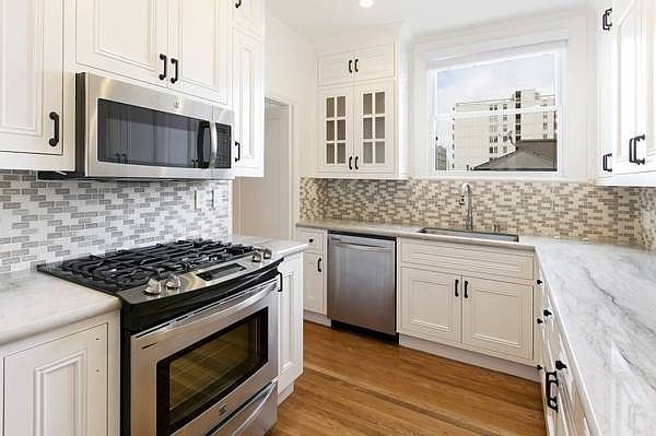 Unit #402 REMODELED kitchen with stainless steel appliances, custom cabinetry and stunning marble countertops!