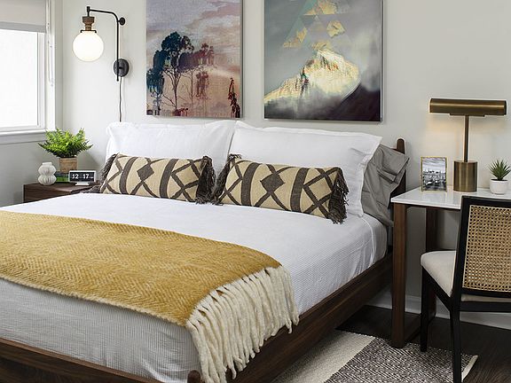 Spacious apartment bedroom with wood-style flooring.