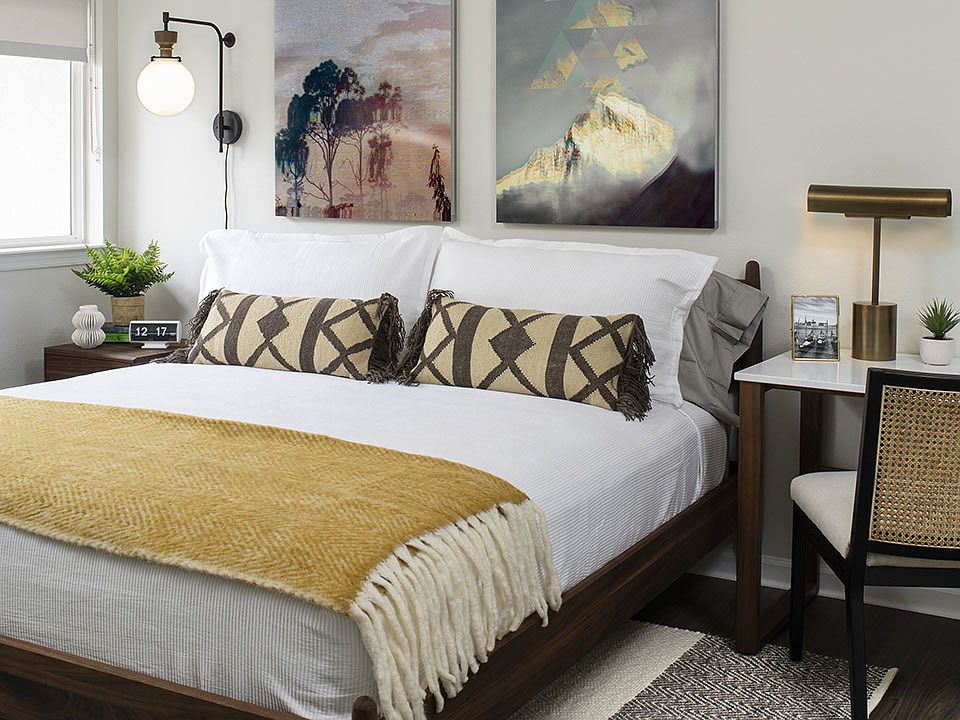 Spacious apartment bedroom with wood-style flooring.