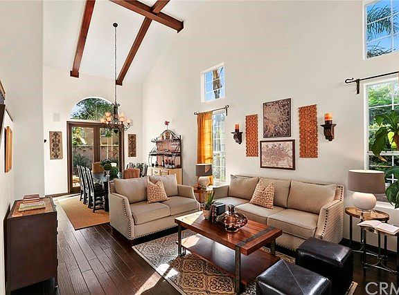 Living and Dining Room with Two Story Beamed Ceiling and Rich Hardwood Flooring