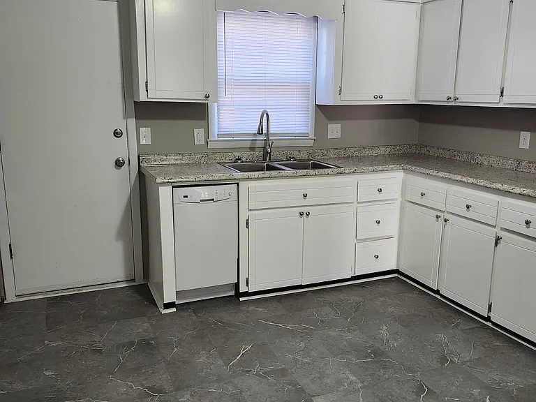 Newly renovated/updated kitchen (new modern beautifully tiled floors and freshly painted kitchen cabinets). View of the backdoor leading to the backyard.