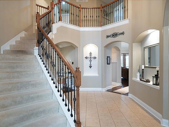 Once inside, a rotunda awaits you with classic details like arched walkways, lighted art niches and a winding wrought iron staircase that leads you upstairs!