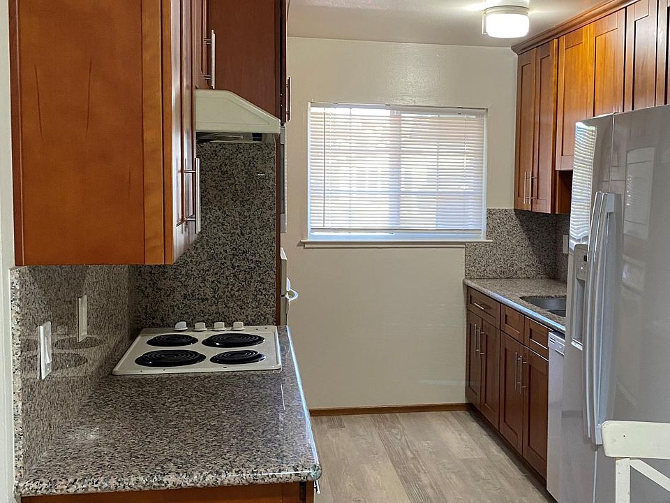 Kitchen with Granite countertops, microwave, cooktop, disposal, dishwasher refrigerator.