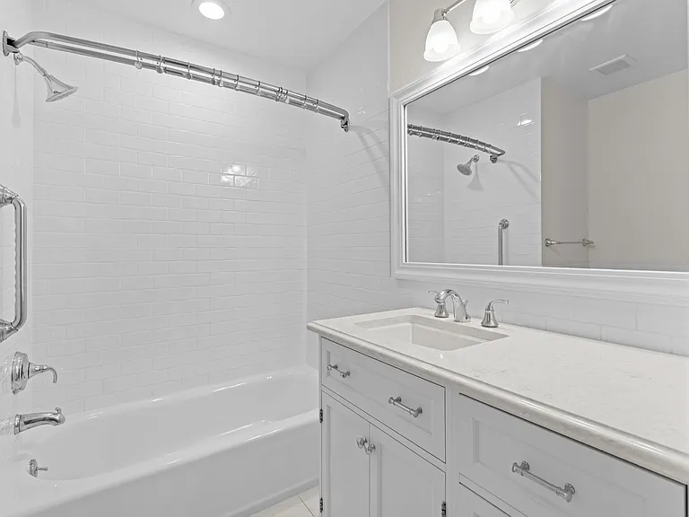 Another view of the upstairs secondary bathroom highlights the spacious vanity, abundant storage, and tub/shower combination.