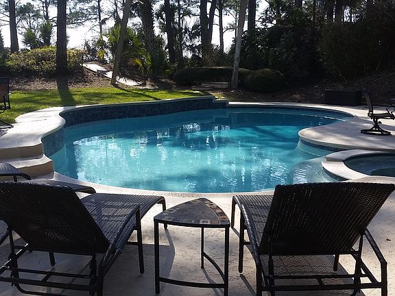 Pool loungers near oversized 35' x 20' pool with spa