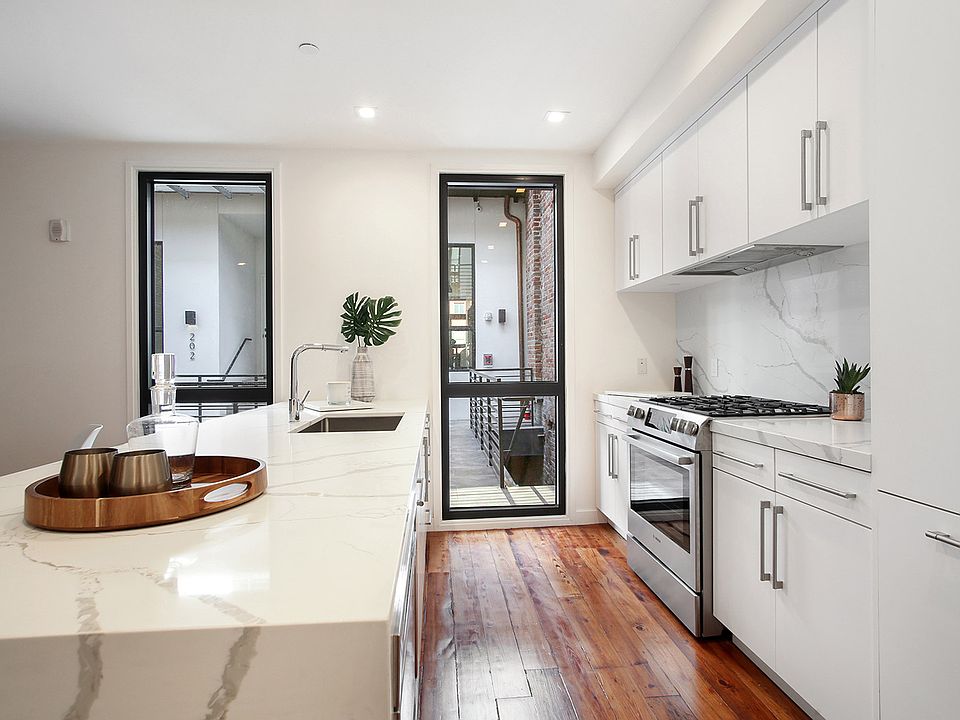 The condo features bookmatched Calacatta quartz countertops and a gas stove.