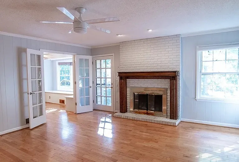 Spacious den with hardwood floor, gas-log fireplace, exits to backyard and screen porch