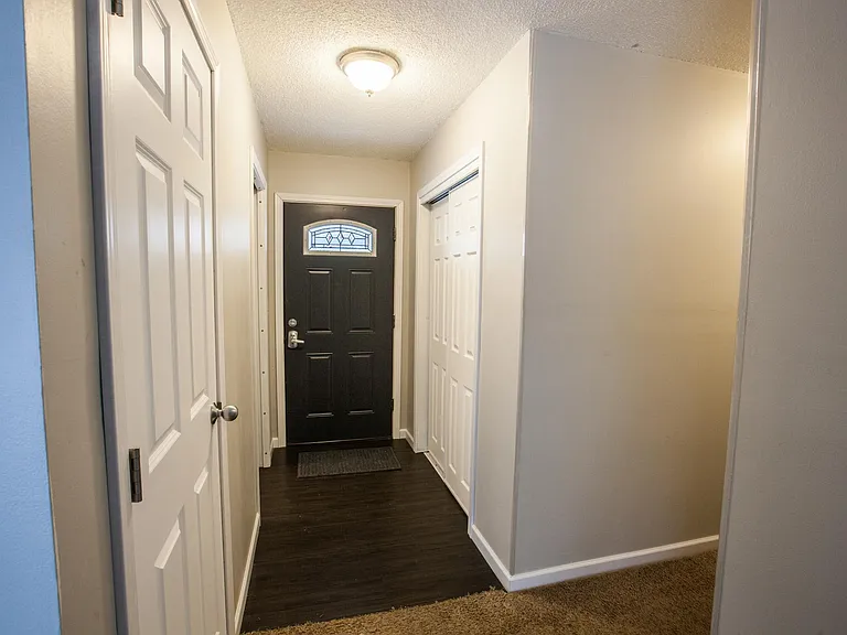 Front door from the inside between kitchen and hallway to the bedrooms