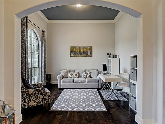 View of the front flexible space with arched openings, hardwood flooring and crown molding