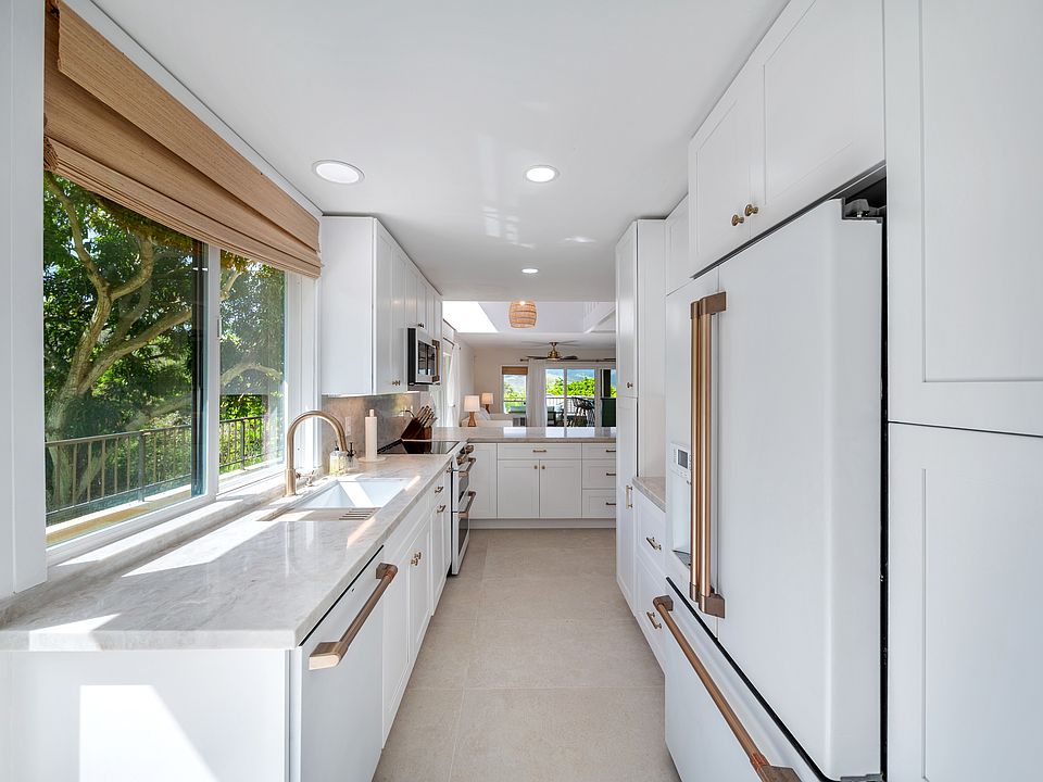 Beautiful, open gourmet kitchen with loads of natural light, slider opens to wrap-around lanai, top tier appliances, and abundant storage.