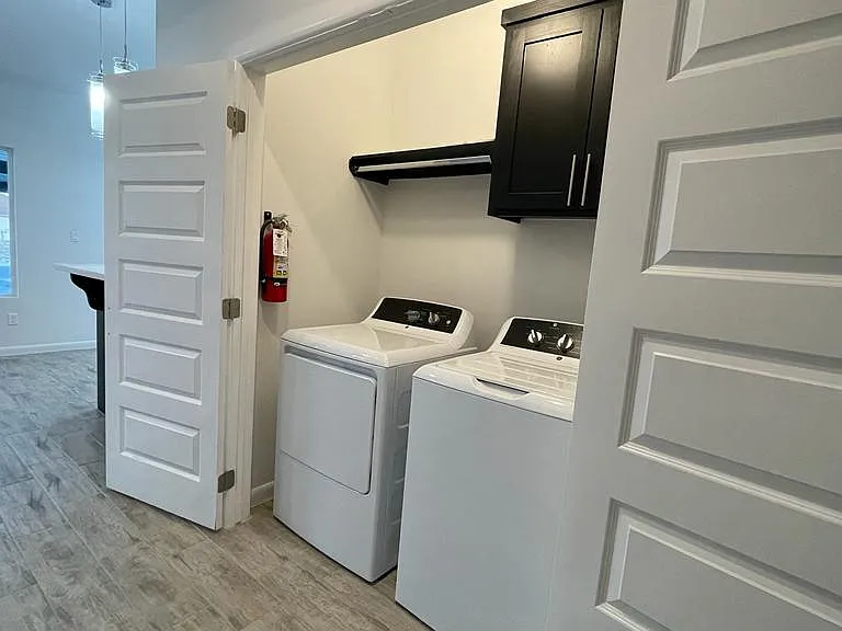 washer and dryer located in the hallway to the bedrooms