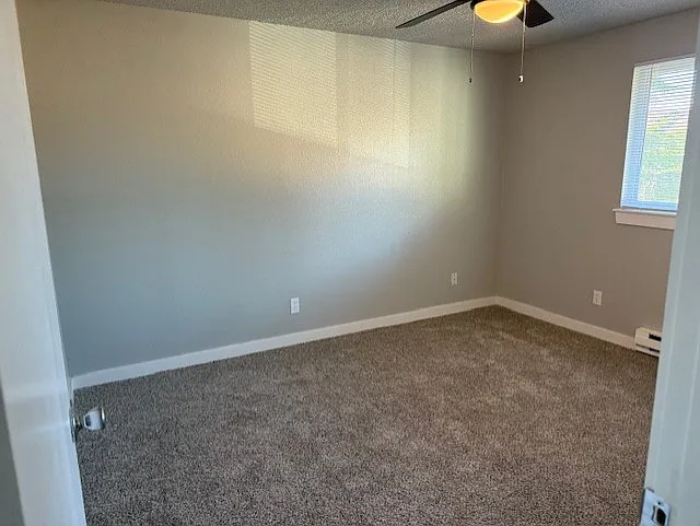 This cozy bedroom loaded with brand new neutral gray carpet and a ceiling fan for those warm evenings.