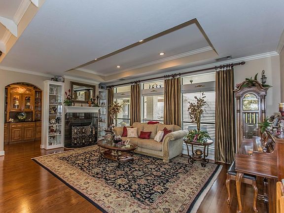 BEAUTIFUL FORMAL LIVING WITH FIREPLACE AND WINDOWS LOOKING ONTO BACK PORCH AND POOL, ALSO NOTICE THE INVITING BUTLER'S PANTRY