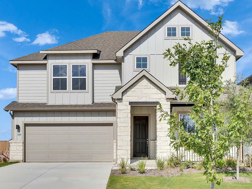Elegant stone facade and lush landscaping at 105 Greinert Drive in Spring Creek.