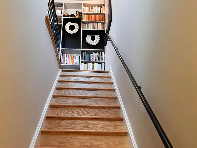 Stairs up to 3rd floor; two guest bedrooms, full bath and sitting area overlooking the rooftop with custom bookcase.